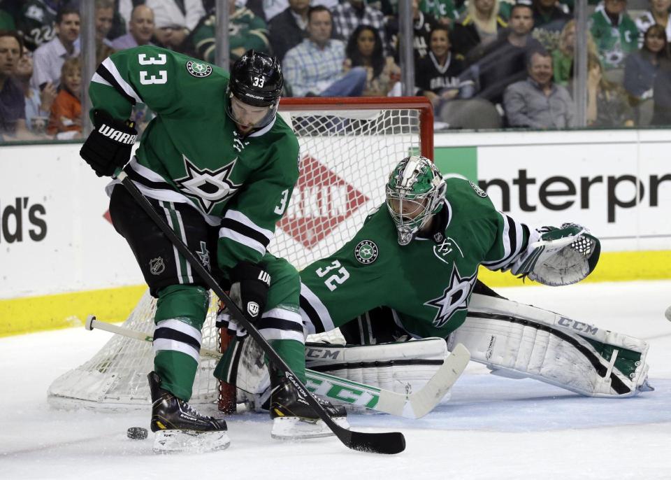 Dallas Stars' Alex Goligoski (33) helps goalie Kari Lehtonen (32) of Finland clear the puck away from the net during the second period of Game 3 of a first-round NHL hockey Stanley Cup playoff series game against the Anaheim Ducks, Monday, April 21, 2014, in Dallas. (AP Photo/Tony Gutierrez)