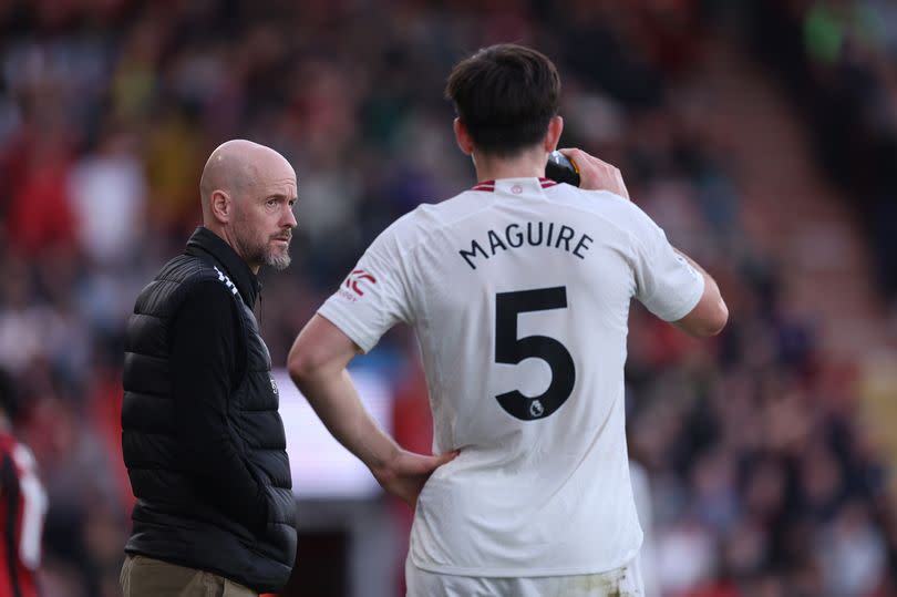 Harry Maguire has a drink at the side of the Vitality Stadium pitch as Erik ten Hag stands looking out onto the surface.