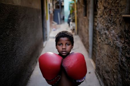 Jandir poses for a photograph in an alley, also known as "viela", in the Mare favela of Rio de Janeiro, Brazil, June 2, 2016. REUTERS/Nacho Doce