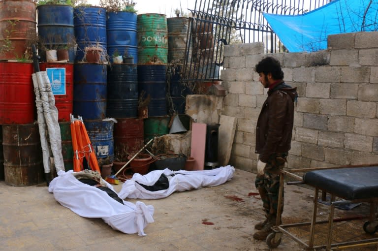 A man stands next to the bodies of victims killed earlier in the day following a reported attack by airstrike on the Sakhour eastern neighbourhood, in the northern Syrian city of Aleppo, on February 5, 2016