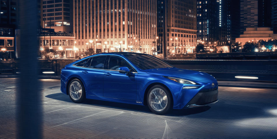 The 2021 Toyota Mirai fuel-cell vehicle cruising through a city environment.