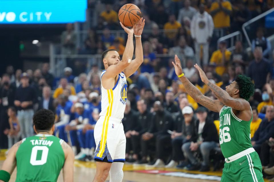 Golden State Warriors guard Stephen Curry (center) shoots the ball over Boston Celtics guard Marcus Smart (36) during the first quarter in game one of the 2022 NBA Finals at Chase Center on Jun 2, 2022.