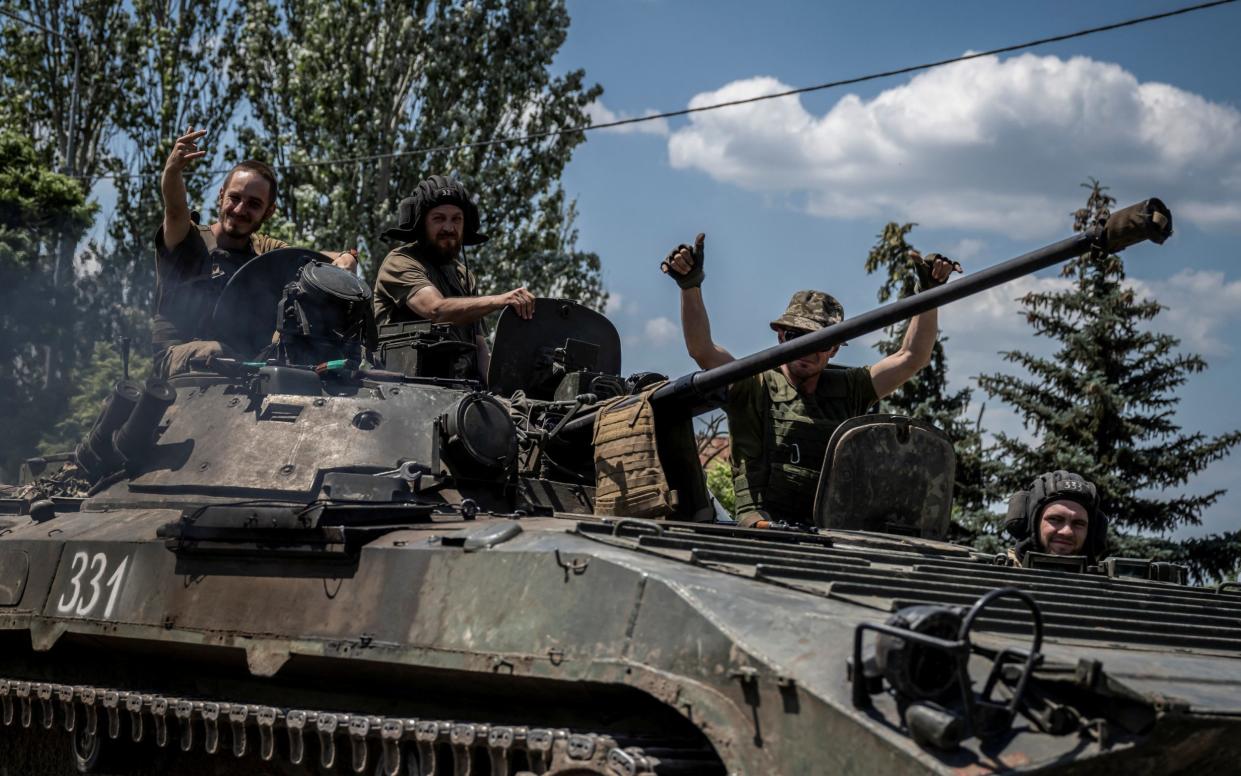 Ukrainian service members ride a BMP-1 infantry fighting vehicle near the front line city of Bakhmut - Reuters