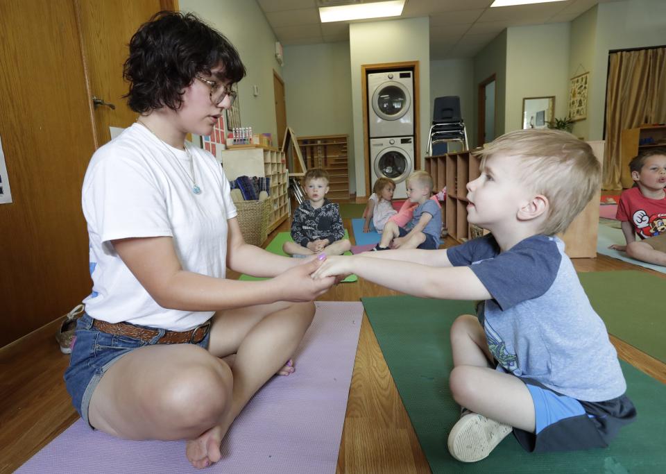 Maddy Sosa-Jaramillo assists Lincoln in a yoga class at Fox Valley Montessori Academy Monday, May 22, 2023, in Appleton, Wis.