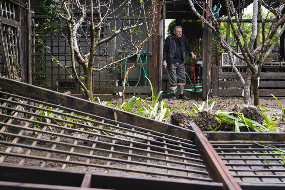 Richard Shaffer surveys his fallen fence in the Felton Grove neighborhood after the San Lorenzo River overflowed in Felton, Calif., Tuesday, Jan. 10, 2023. (AP Photo/Nic Coury)