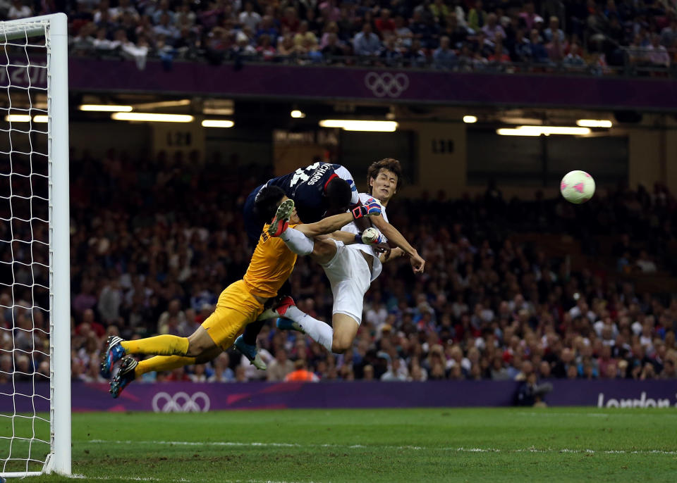 Micah Richards of Great Britain goes for the ball wiith Sungryong Jung of Korea and Dongwon Ji of Korea during the Men's Football Quarter Final match between Great Britain and Korea, on Day 8 of the London 2012 Olympic Games at Millennium Stadium on August 4, 2012 in Cardiff, Wales. (Photo by Julian Finney/Getty Images)