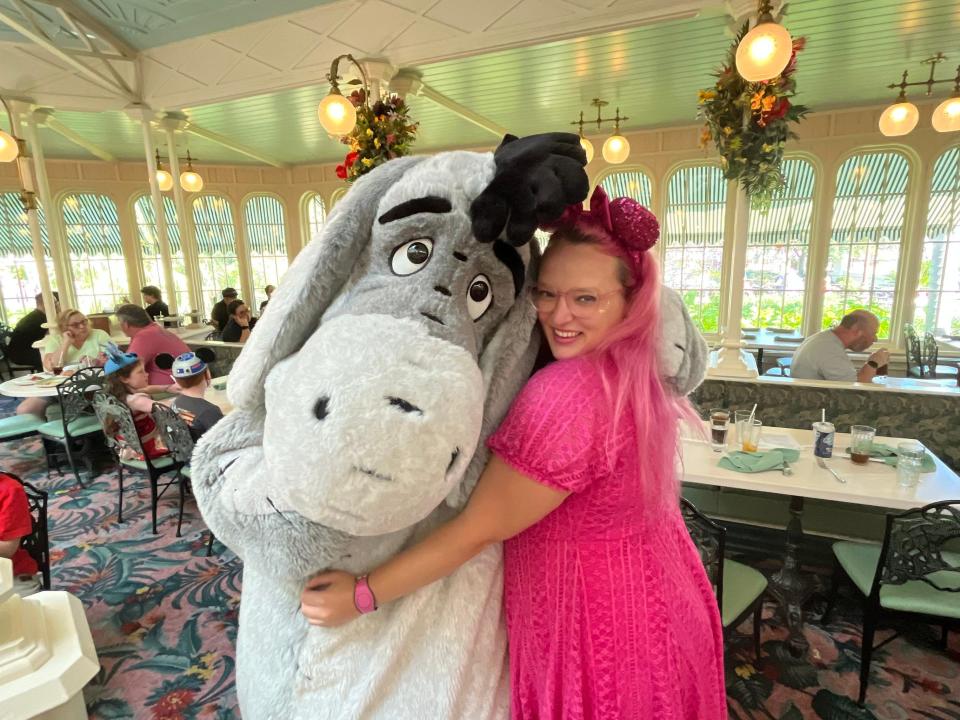 casey posing for a photo with eyore at crystal palace in magic kingdom