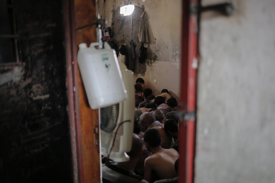 FILE - In this Tuesday, July 18, 2017 file photo, Suspected Islamic State members sit inside a small room in a prison south of Mosul, Iraq. A leading international human rights organization is criticizing the Iraqi government for holding thousands of prisoners, including children, in degrading and "inhuman" conditions. (AP Photo/Bram Janssen, File)