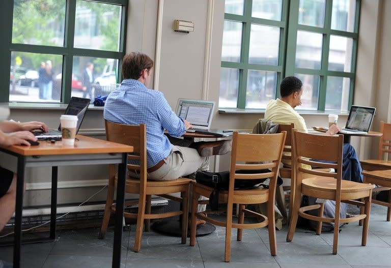 People use their laptop computers at a starbucks in Washington, DC, on May 9, 2012. The source behind bombshell leaks of US monitoring of Internet users and phone records says his sole motive was to inform the public and prevent the US government from destroying privacy and basic liberties
