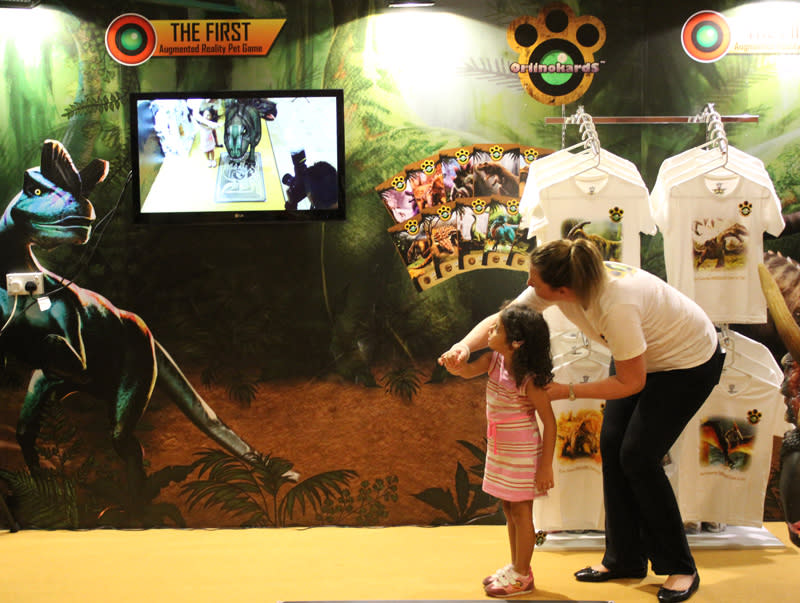 One of Oriinokards' founders, Nicola Ransome-Goh, teaching a volunteer to how to play with a T-Rex.