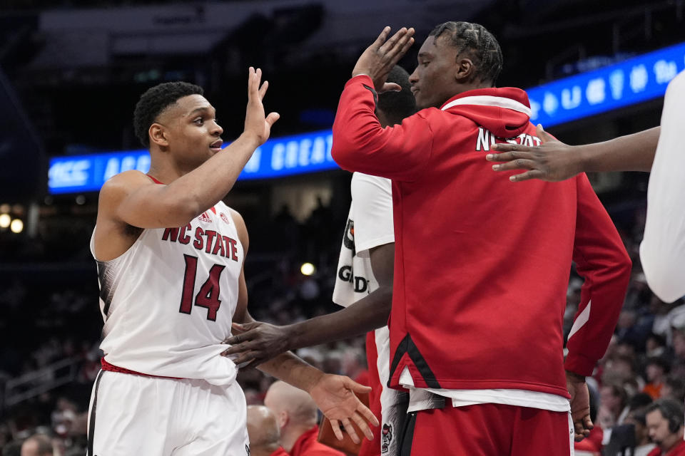 North Carolina State guard Casey Morsell (14) is greeted by teammates near the end of the second half of the Atlantic Coast Conference NCAA college basketball tournament game against Louisville, Tuesday, March 12, 2024, in Washington. North Carolina State won 94-85. (AP Photo/Alex Brandon)