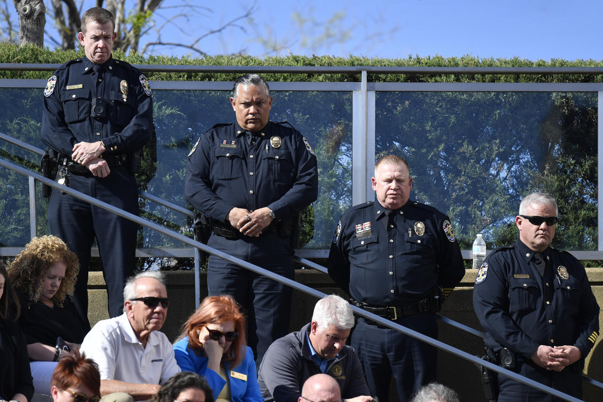 Officers with the Louisville Metro Police Department participate in a moment of silence during a vigil for the victims of Monday&#39;s shooting at the Old National Bank in Louisville, Ky., Wednesday, April 12, 2023. (AP Photo/Timothy D. Easley)