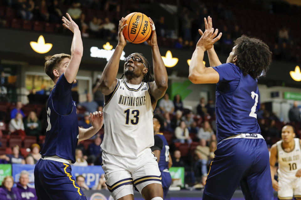 Montana State forward Jubrile Belo (13) turns to the basket in between two Northern Arizona defenders in the first half of an NCAA college basketball game for the championship of the Big Sky men's tournament in Boise, Idaho, Wednesday, March 8, 2023, (AP Photo/Steve Conner)