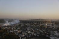 In this Thursday, Feb. 20, 2020, photo, smoke from a pest fumigation rises from the newly constructed Sardar Patel Gujarat Stadium that U.S. President Donald Trump will be visiting, in Ahmedabad, India. A festive mood has enveloped Ahmedabad in India’s northwestern state of Gujarat ahead of Prime Minister Narendra Modi's meeting Monday with Trump, whom he's promised millions of adoring fans. The rally in Modi's home state may help replace his association with deadly anti-Muslim riots in 2002 that landed him with a U.S. travel ban. It may also distract Indians, at least temporarily, from a slumping economy and ongoing protests over a citizenship law that excludes Muslims, but also risks reopening old wounds. (AP Photo/Ajit Solanki)