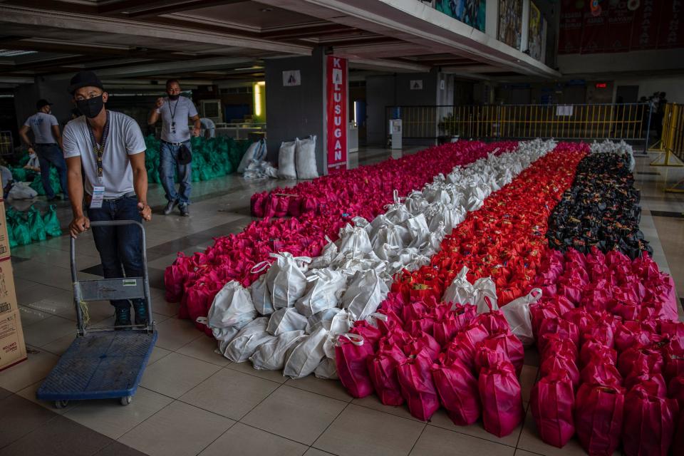 Volunteers pack relief goods for residents running out of food and supplies as they undergo home quarantine on March 20, 2020 in Quezon city, Metro Manila, Philippines.