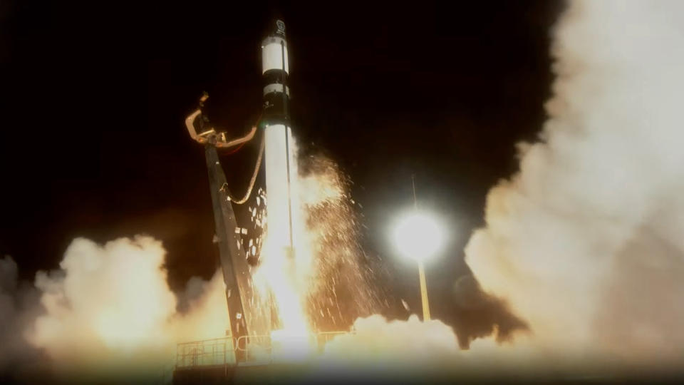 Бело-черная ракета Rocket Lab Electron взлетает в ночное небо, из нее вылетают искры, 18 февраля 2024 года.