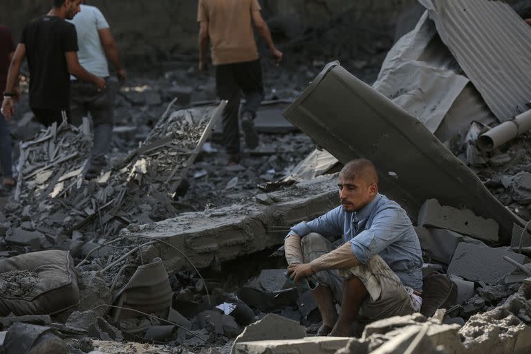 Un hombre sentado en los escombros de edificios destruidos en ataques aéreos israelíes, en la Ciudad de Gaza.