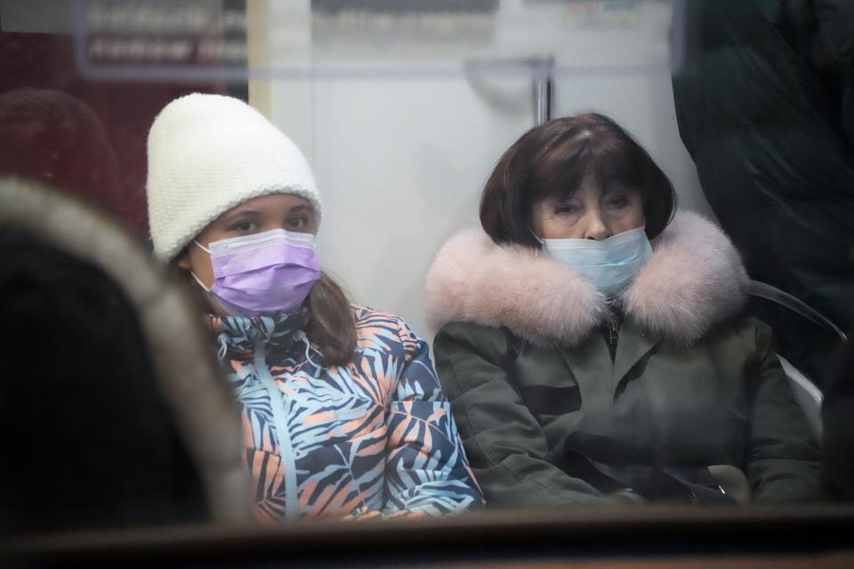 People wearing face masks to help protect against the spread of the coronavirus ride a subway car in an underground in St. Petersburg, Russia, Friday, Jan. 21, 2022. Daily new coronavirus infections in Russia have reached an all-time high and authorities are blaming the highly contagious omicron variant, which they expect to soon dominate the country's outbreak. Record numbers of new cases were reported in Moscow and in St. Petersburg, where health officials on Friday limited elective outpatient care.(AP Photo/Dmitri Lovetsky)