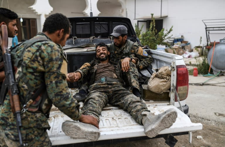 A heavily wounded member of the Syrian Democratic Forces smiles as he arrives at a medical centre on the eastern frontline of the battle to retake the one-time Islamic State bastion of Raqa