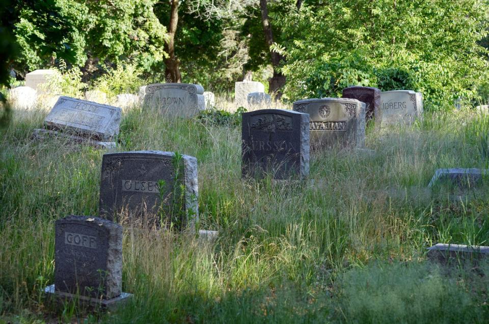 Graves are engulfed by overgrown grass and weeds at Oakland Cemetery. The City of Cranston has taken the cemetery's owner to court over zoning violations.