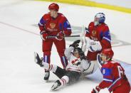 Canada's Sam Reinhart (C) falls between Russia's Nikita Tryamkin (L) and goalie Andrei Vasilevski during the first period of their IIHF World Junior Championship ice hockey game in Malmo, Sweden, January 5, 2014. REUTERS/Alexander Demianchuk (SWEDEN - Tags: SPORT ICE HOCKEY)