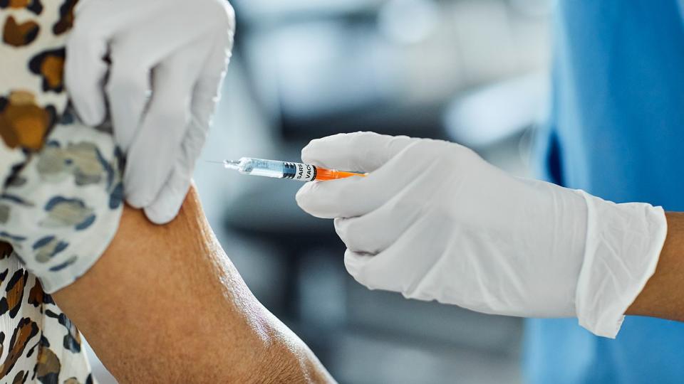 Cropped image of nurse injecting Covid-19 Vaccine to a patient. Female healthcare worker is working at hospital. She is holding syringe.