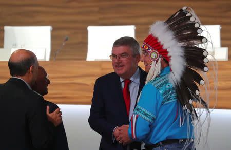 Thomas Bach, President of the International Olympic Committee (IOC), shakes hands with Wilton Littlechild, an observer of the 133rd IOC session, as they talk to other attendants in Buenos Aires, Argentina October 9, 2018. REUTERS/Marcos Brindicci