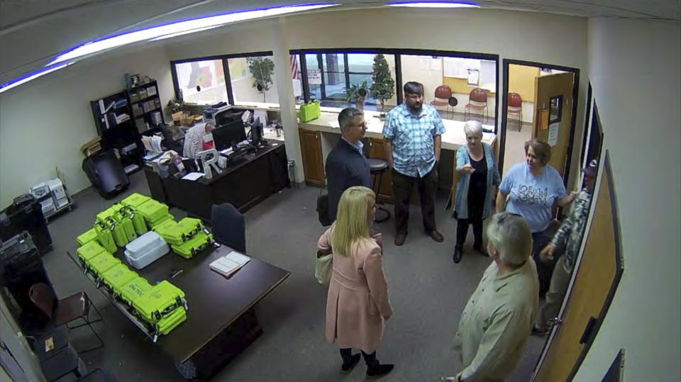 FILE - This Jan. 7, 2021, image taken from Coffee County, Ga., security video, appears to show Cathy Latham (center, long turquoise top), introducing members of a computer forensic team to local election officials. Latham was the county Republican Party chair at the time. The computer forensics team was at the county elections office in Douglas, Ga., to make copies of voting equipment in an effort that documents show was arranged by attorney Sidney Powell and others allied with then-President Donald Trump. (Coffee County, Georgia via AP)