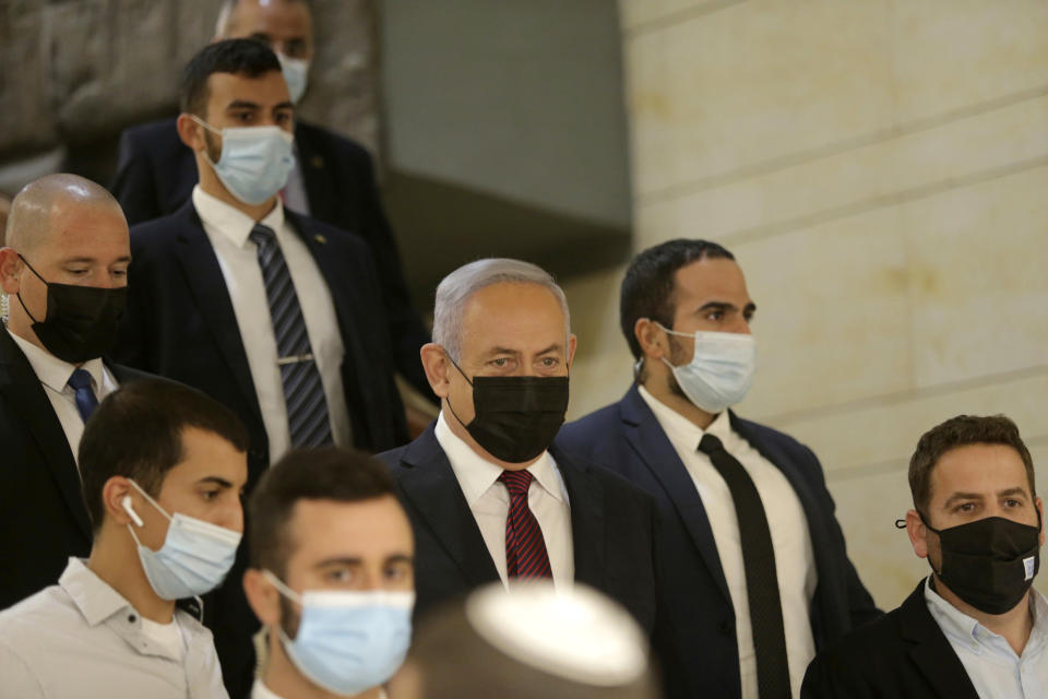 Israeli Prime Minister Benjamin Netanyahu, center, arrives at the Israeli Knesset (Parliament) ahead of a vote to dissolve the Knesset, in Jerusalem, Wednesday, Dec. 2 2020. The Israeli parliament passed a preliminary proposal to dissolve itself on Wednesday, setting up a possible fourth national election in under two years while the country is in the grip of the coronavirus pandemic.(Alex Kolomoisky/Pool via AP)