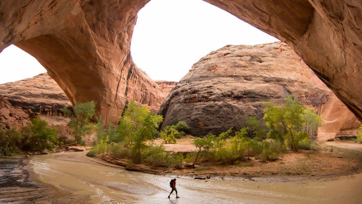 <span class="article__caption">Hiking under arches in Escalante, Utah</span> (Photo: Jordan Siemens/Getty)