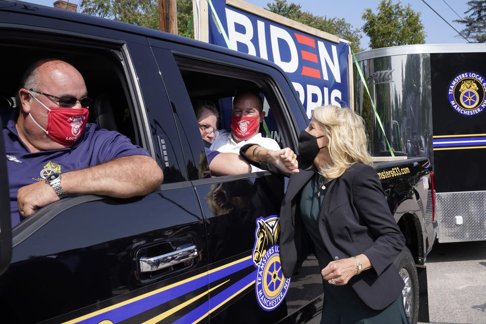 ARCHIVO - En esta foto de archivo del 16 de septiembre de 2020, Jill Biden, esposa del exvicepresidente demócrata Joe Biden, saluda a los miembros de Teamsters Union Roger Tavers, izquierda, y Matt Lortie, segundo desde la derecha, ambos de Manchester, NH, mientras choca los codos con una persona no identificada durante una parada de campaña en Manchester. El viernes 25 de septiembre de 2020, The Associated Press informó sobre publicaciones en las redes sociales que circulaban en línea informando incorrectamente que sólo cinco autos formaban parte de un desfile en una parada de la campaña de Biden que tuvo lugar el 16 de septiembre de 2020 en Manchester. De hecho, decenas de autos participaron en el desfile. (AP Foto/Steven Senne, archivo)