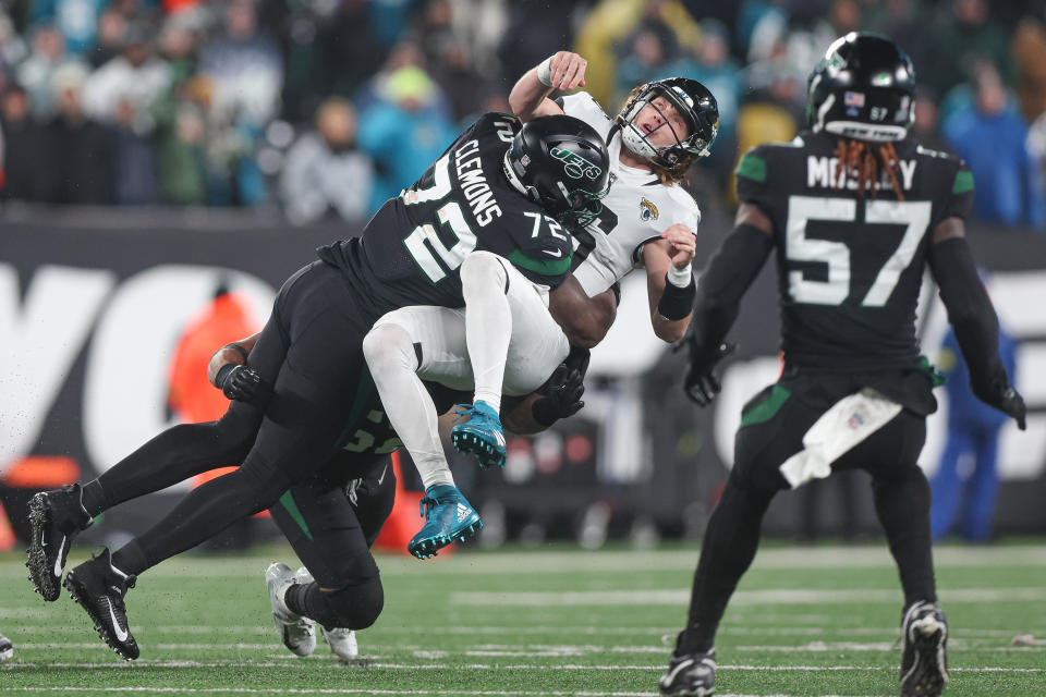 Dec 22, 2022; East Rutherford, New Jersey; Jacksonville Jaguars quarterback Trevor Lawrence (16) is hit by New York Jets defensive end Micheal Clemons (72) while throwing the ball during the second half in front of linebacker C.J. Mosley (57) at MetLife Stadium. Vincent Carchietta-USA TODAY Sports