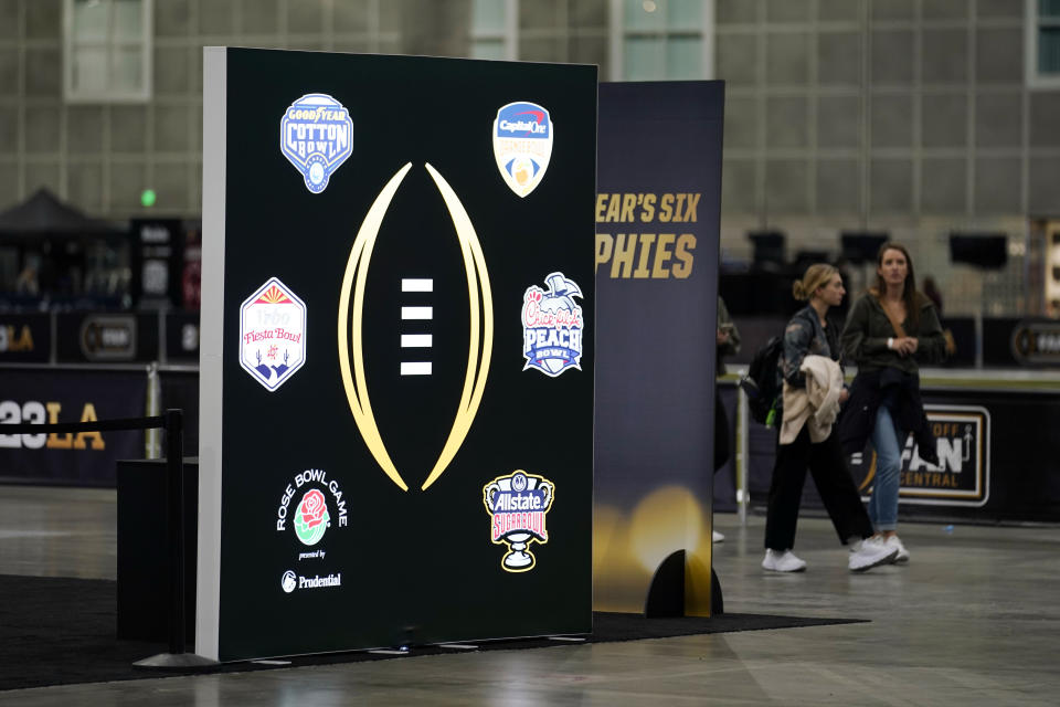 CFP and bowl logos are flashed on a screen at a fan fest at the Los Angeles Convention Center, Thursday, Jan. 5, 2023, in Los Angeles. Georgia is scheduled to face TCU, Monday for the CFP national football championship in Inglewood, Calif. (AP Photo/Marcio Jose Sanchez)