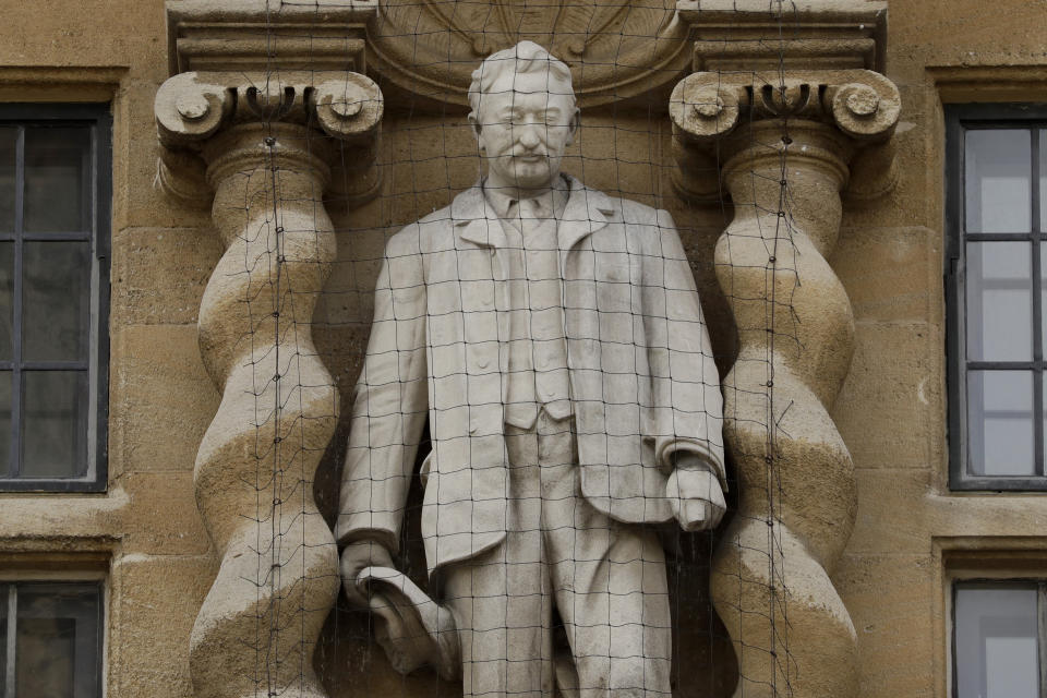 A statue of Cecil Rhodes, the controversial Victorian imperialist who supported apartheid-style measures in southern Africa stands mounted on the facade of Oriel College in Oxford, England, Wednesday, June 17, 2020. The governing body of Oriel College are meeting today to discuss the future of the statue. (AP Photo/Matt Dunham)