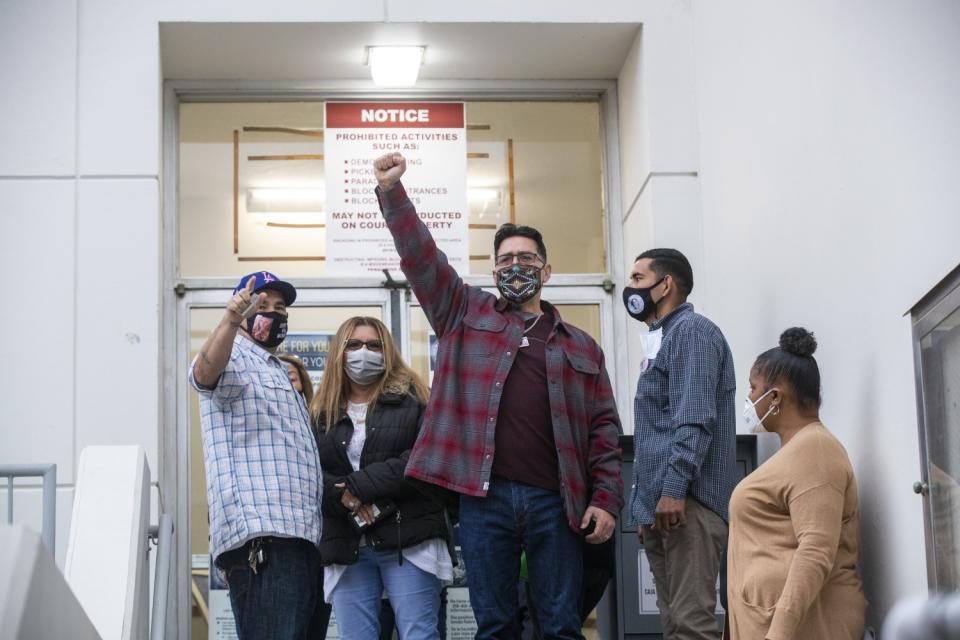 Richard Cartier raises his fist in solidarity to supporters outside the Inglewood Juvenile Courthouse.