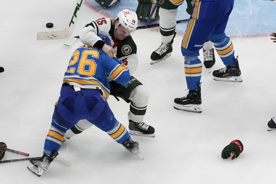 Minnesota Wild's Mason Shaw (15) and St. Louis Blues' Nathan Walker (26) fight during the third period of an NHL hockey game Saturday, March 16, 2024, in St. Louis. (AP Photo/Jeff Roberson)