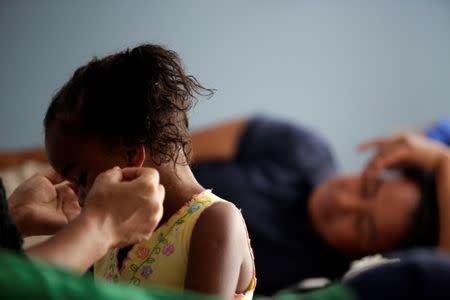 A Honduran migrant child is groomed by her mother at the Senda de Vida migrant shelter in Reynosa, in Tamaulipas state, Mexico June 22, 2018. Picture taken June 22, 2018. REUTERS/Daniel Becerril