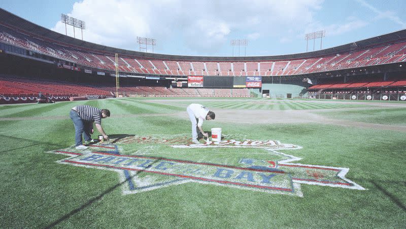 Rich Virgil, left, and Rick Ayers repaint the “Battle of the Bay World Series” logo on the grass at Candlestick Park in San Francisco, Thursday, Oct. 26, 1989. The Series had been interrupted by a powerful earthquake on Oct. 17.