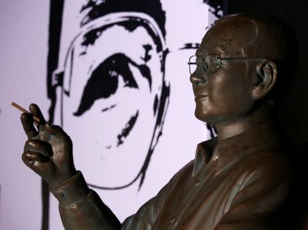 A statue of Nobel Peace Prize-winning dissident Liu Xiaobo is displayed in front of his portrait, during a candlelight vigil to mark the first anniversary of Liu's death, in Hong Kong, China July 13, 2018. REUTERS/Bobby Yip