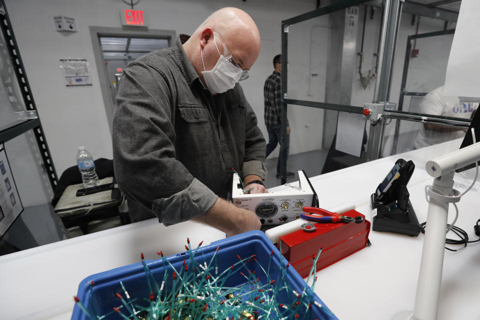 Ford Motor Co., assemblyman Malcolm Brumwell puts together a ventilator that the automaker is assembling at the Ford Rawsonville plant, Wednesday, May 13, 2020 in Ypsilanti Township, Mich. The plant was converted into a ventilator factory, as hospitals battling the coronavirus report shortages of the life-saving devices. The company has promised to deliver 50,000 by July 4. (AP Photo/Carlos Osorio)