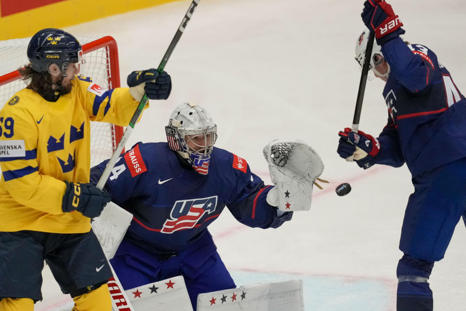 Unted States' goalkeeper Alex Lyon, center, makes a save in front of Sweden's Linus Johansson, left, during the preliminary round match between Sweden and United States at the Ice Hockey World Championships in Ostrava, Czech Republic, Friday, May 10, 2024. (AP Photo/Darko Vojinovic)