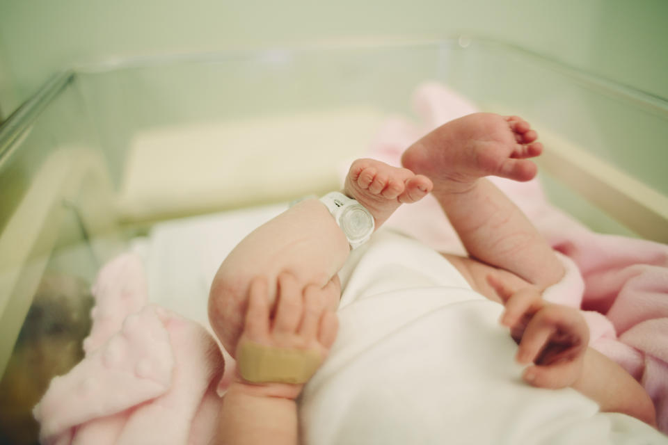 View of baby's feet with a hospital security tag on