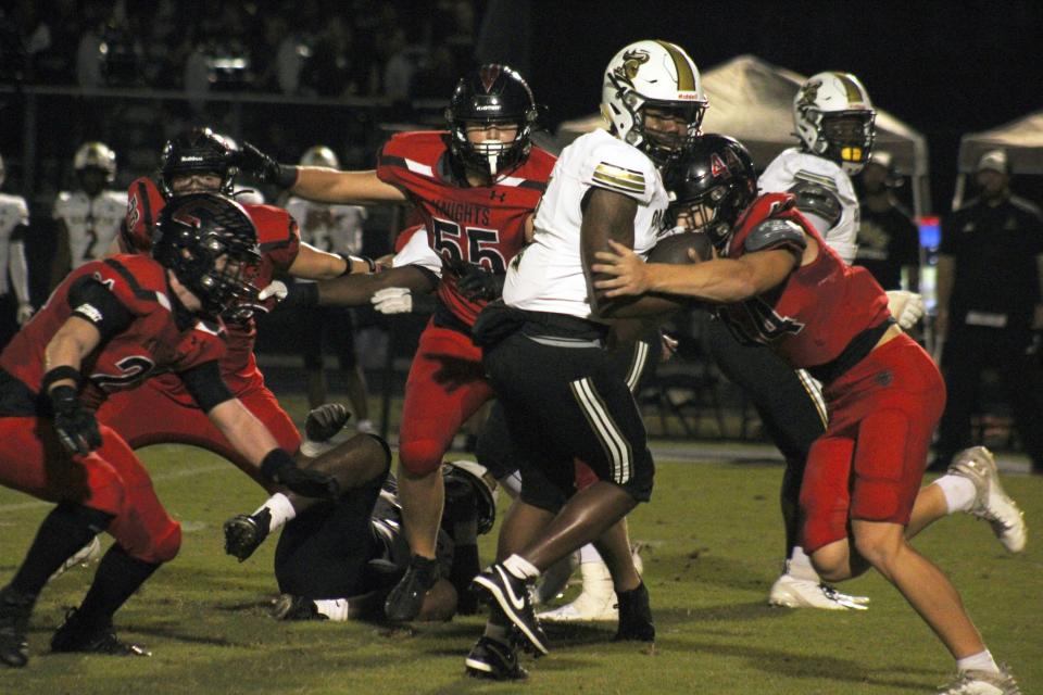 Creekside's Brody McGough (21), Cole Long (55) and Tyce Donnelly (44) prepare to wrap up Oakleaf quarterback Brandon Wallace Jr. (7) for a sack during a high school football game on September 29, 2023. [Clayton Freeman/Florida Times-Union]