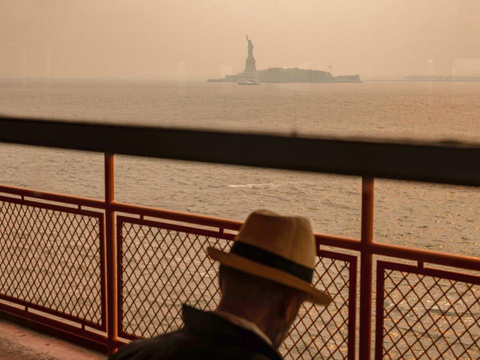 The Statue of Liberty, covered in a haze-filled sky, is photographed from the Staten Island Ferry, June 7, 2023, in New York.