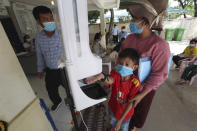 A young boy, center, disinfects his hands before receiving a shot of the Sinovac's COVID-19 vaccine at Samrong Krom health center outside Phnom Penh, Cambodia, Friday, Sept. 17, 2021. Prime Minister Hun Sen announced the start of a nationwide campaign to give COVID-19 vaccinations to children between the ages of 6 and 11 so they can return to school safely after a long absence due to measures taken against the spread of the coronavirus. (AP Photo/Heng Sinith)