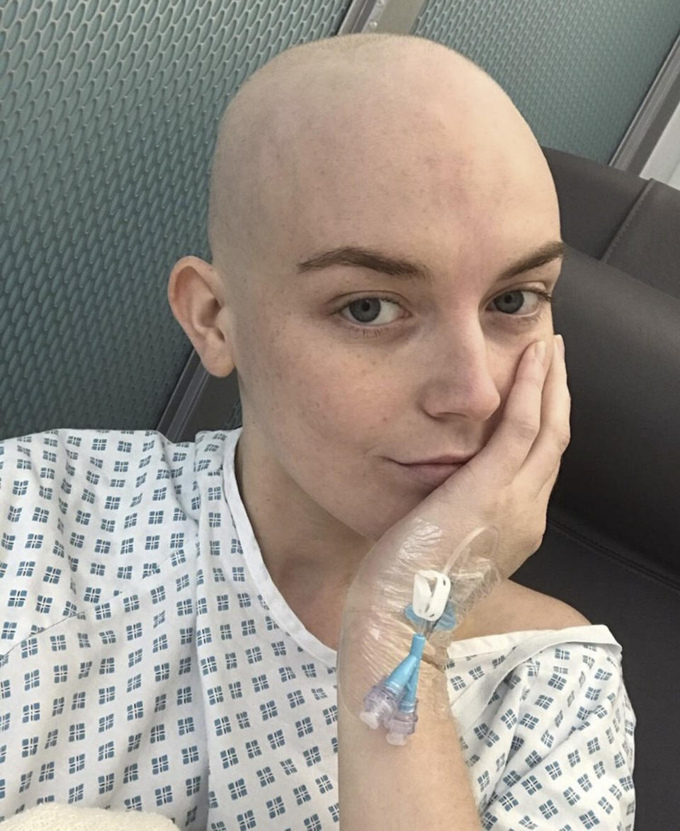 A photo of Georgie Swallow wearing a hospital gown during her treatment for Hodgkin’s lymphoma.