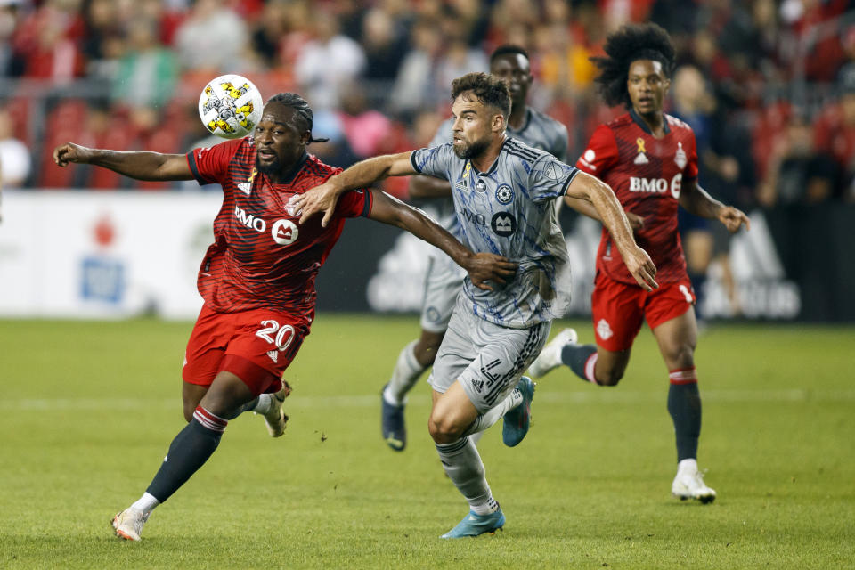 Toronto FC forward Ayo Akinola (20) and Montreal defender Rudy Camacho (4) battle for the ball during first half MLS soccer action in Toronto on Sunday, Sept. 4, 2022. (Cole Burston/The Canadian Press via AP)