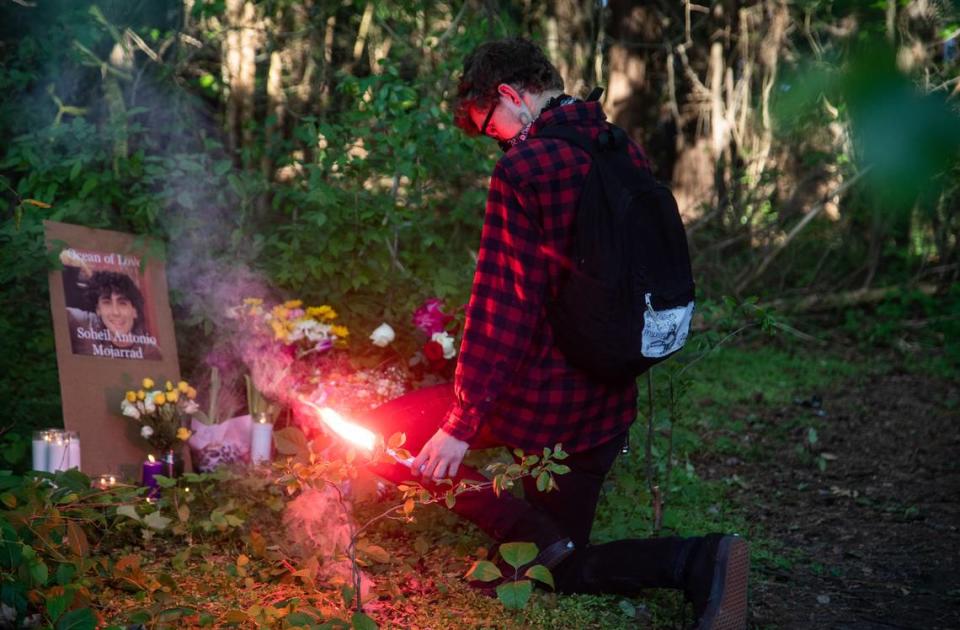 A mourner burns a flare at a makeshift memorial following a vigil for Soheil Antonio Mojarrad, 30, of Raleigh near a shopping center off New Bern Avenue in Raleigh Tuesday, April 23, 2019. Mojarrad was killed in an officer-involved shooting Saturday.