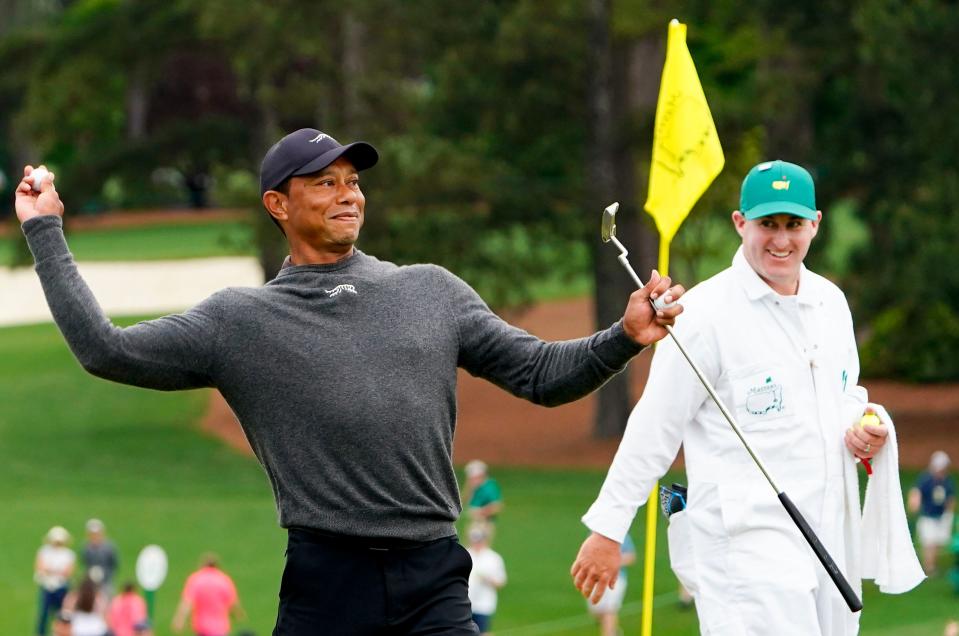 Tiger Woods throws a ball to a patron from the no. 9 green during a practice round for the Masters Tournament golf tournament at Augusta National Golf Club.