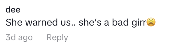 The image displays a social media comment reading "She warned us... she's a bad girrr" with a sad face emoji, posted by a user named dee